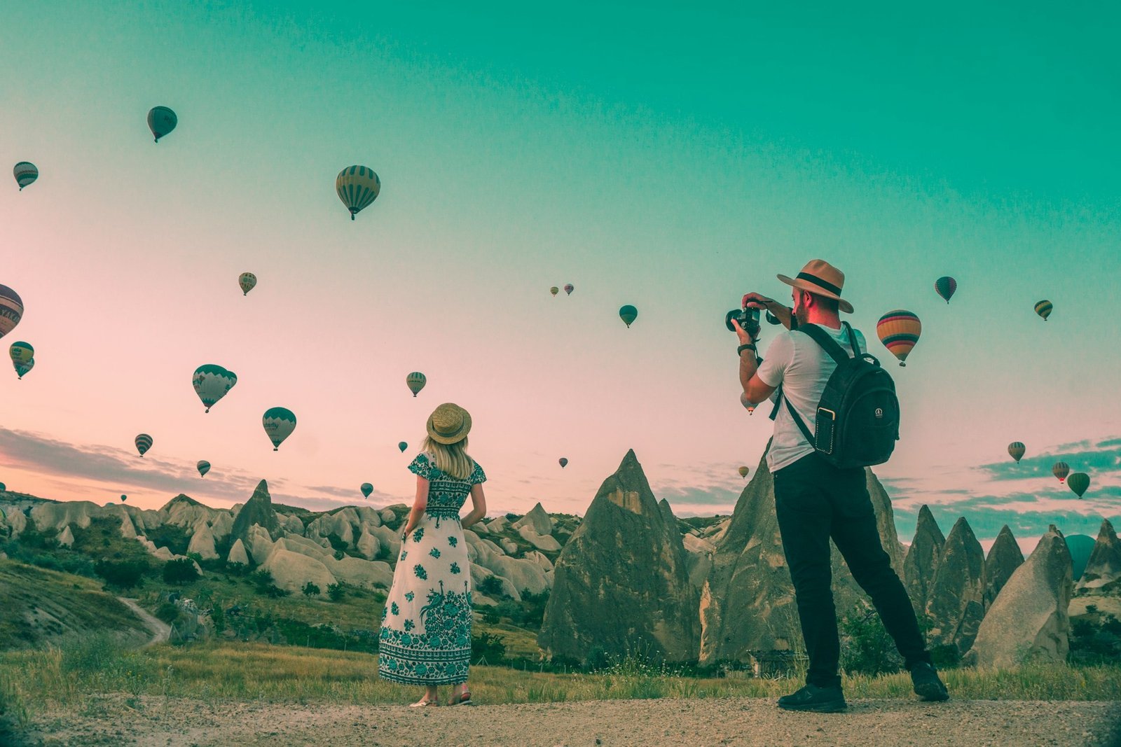 Hundreds of baloons drift across sky as man and wome discover slow travel destinations